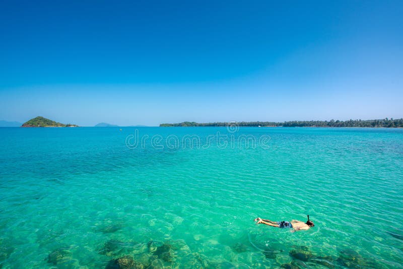 Turister snorklar i crystal turkosvatten n?ra tropisk semesterort i Phuket, Thailand. Sommar-, semester-, lopp- och feriebegrepp royaltyfri fotografi Turister snorklar i crystal turkosvatten n?ra tropisk semesterort i Phuket, Thailand. Sommar-, semester-, lopp- och feriebegrepp royaltyfri fotografi