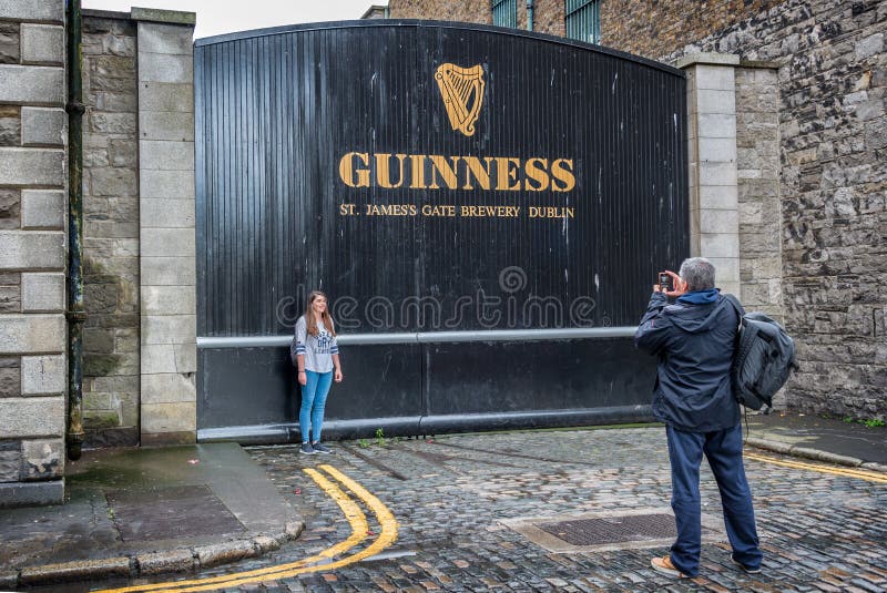 Turister som tar fotoet på Sten James Gate av det Guinness magasinbryggeriet i Dublin arkivbilder