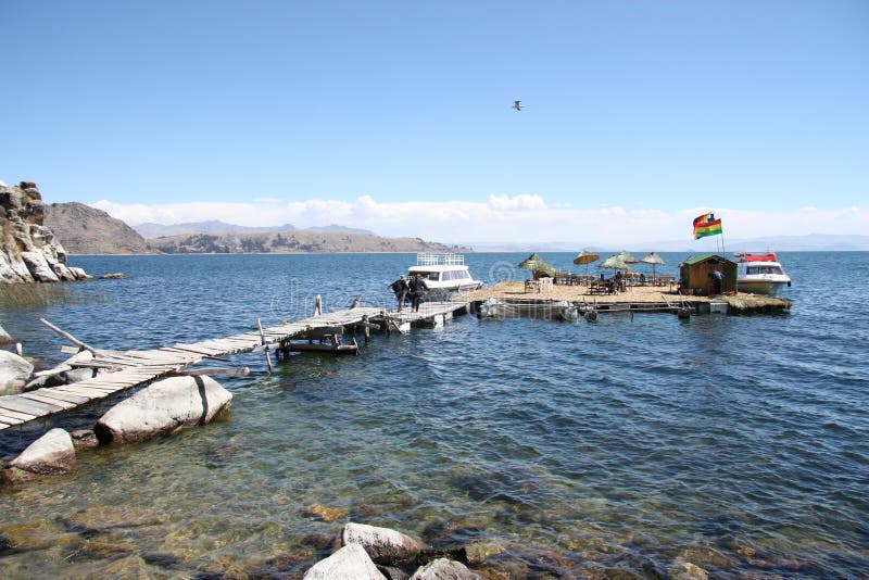 Turisti all'isola di galleggiamento sul lago Titicaca, Bolivia fotografia stock Turisti all'isola di galleggiamento sul lago Titicaca, Bolivia fotografia stock