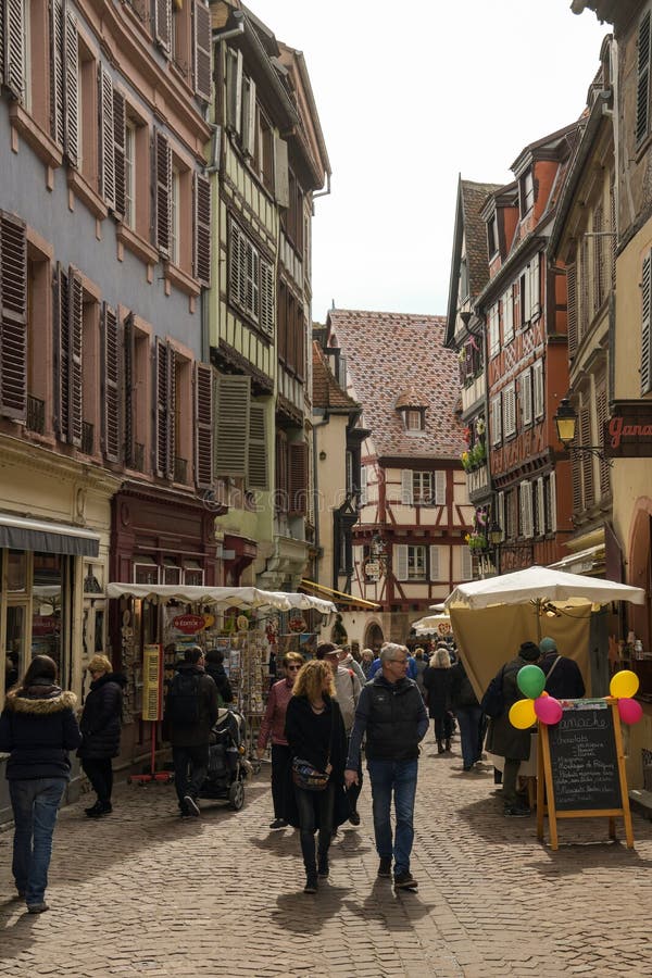 Turisti che camminano tramite le vie in vecchia città mediaval di Colmar fotografia stock Turisti che camminano tramite le vie in vecchia città mediaval di Colmar fotografia stock