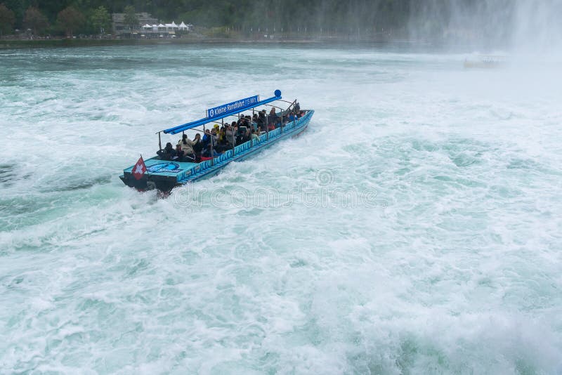 Turisti che godono del viaggio della barca in cascata di Rheinfall in Svizzera fotografia stock libera da diritti Turisti che godono del viaggio della barca in cascata di Rheinfall in Svizzera fotografia stock libera da diritti