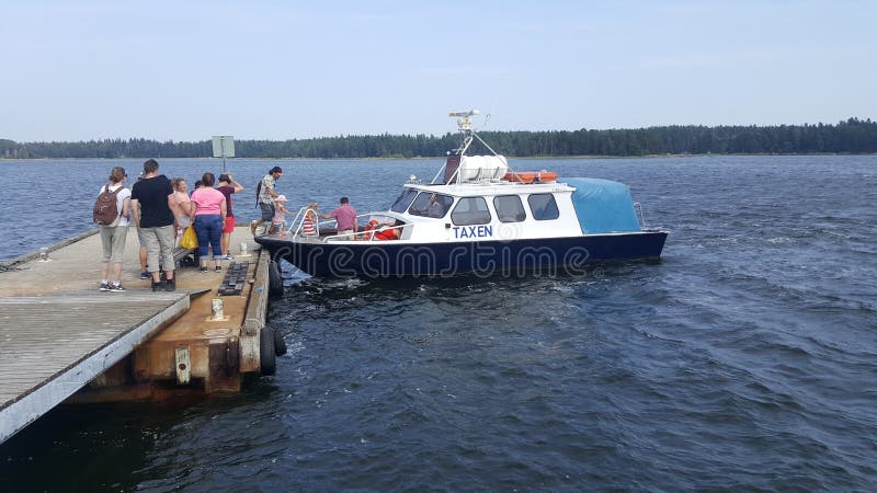 Turisti che registrano un taxi della barca nel porto della fortezza di Svartholm in Loviisa, Finlandia immagine stock libera da diritti Turisti che registrano un taxi della barca nel porto della fortezza di Svartholm in Loviisa, Finlandia immagine stock libera da diritti
