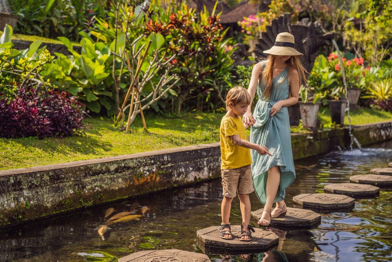 Turisti del figlio e della mamma in Taman Tirtagangga, palazzo dell'acqua, parco dell'acqua, Bali Indonesia Viaggiando con il con fotografia stock libera da diritti Turisti del figlio e della mamma in Taman Tirtagangga, palazzo dell'acqua, parco dell'acqua, Bali Indonesia Viaggiando con il con fotografia stock libera da diritti
