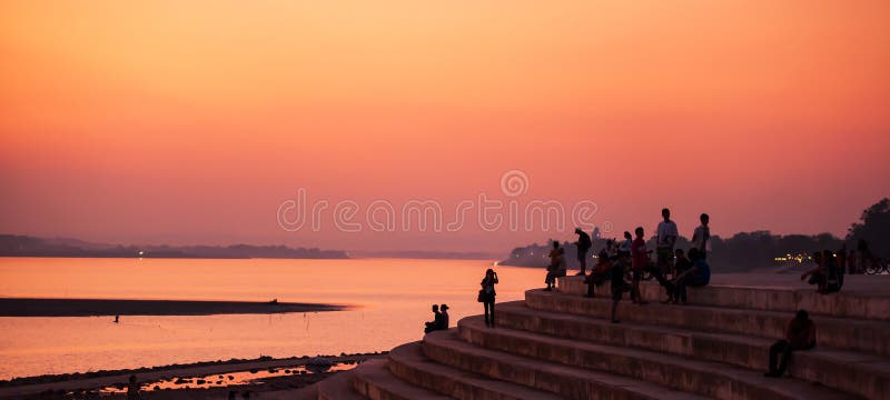 Turisti e laotiano che si rilassano sul pilastro dal Mekong durante il tramonto sereno Vientiane, Laos fotografie stock libere da diritti Turisti e laotiano che si rilassano sul pilastro dal Mekong durante il tramonto sereno Vientiane, Laos fotografie stock libere da diritti