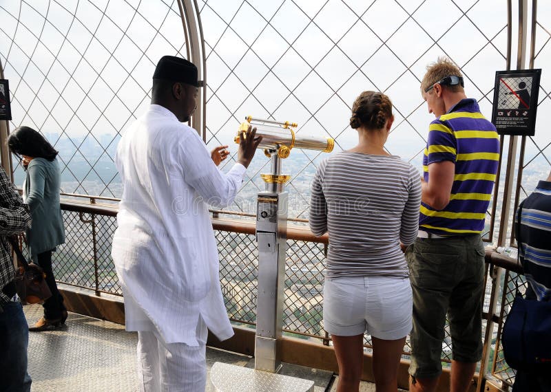 Turisti stranieri con telescopio sulla Torre Eiffel immagine stock libera da diritti