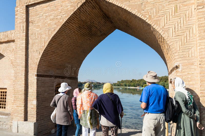 Isfahan, Iran - November 2, 2019: Foreign tourists watching out of the arch of Si-o-Se Pol (Bridge of 33 Arches or Allahverdi Khan Bridge) on Zayanderud River in Isfahan, Iran. Heritage. Isfahan, Iran - November 2, 2019: Foreign tourists watching out of the arch of Si-o-Se Pol (Bridge of 33 Arches or Allahverdi Khan Bridge) on Zayanderud River in Isfahan, Iran. Heritage.