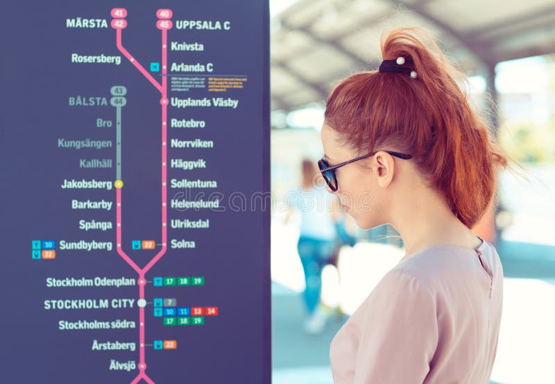 Turistkvinna som tittar på kartan över Stockholms tunnelbana