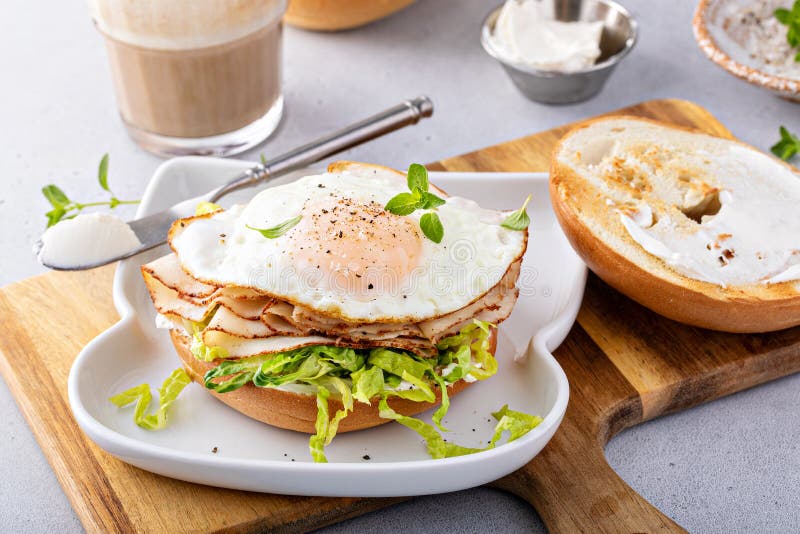 Turkey Bagel Breakfast Sandwich with Lettuce and Fried Egg Stock Photo
