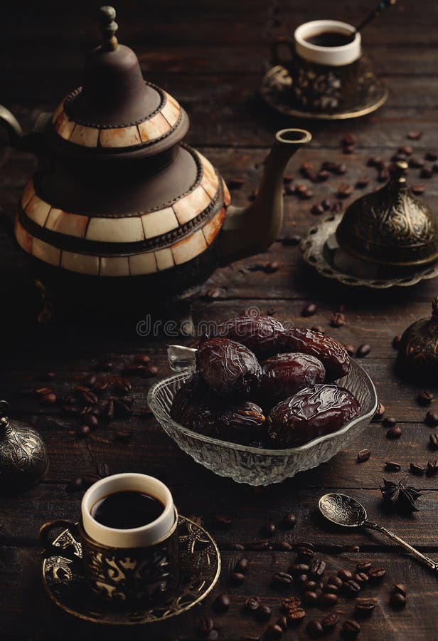 Turkish coffee with dates on a dark wooden table