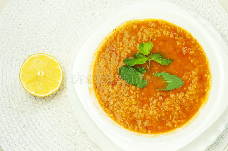 Turecká červená čočka polévka na talíři s mátou a citronem.