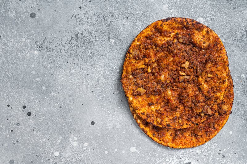 Turkish pizza lahmacun on kitchen table. Gray background. Top view. Copy space royalty free stock image