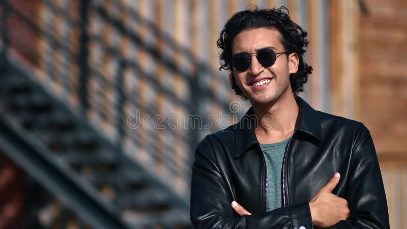 Turkish smiling brutal guy in black leather jacket and sunglasses posing outdoor downtown building stock video footage