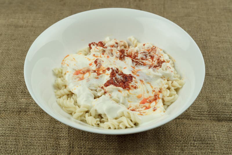 Turkish stile spiral pasta is served with yogurt and tomato sauce