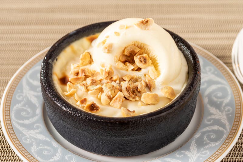 Turkish Sutlac or Oven Rice Pudding with Hazelnuts in Clay Bowl Stock