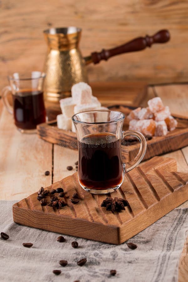 Turkiskt kaffe in i traditionell präglad metallturk kaffekorn, turk, kaffekvarn på en träbakgrund royaltyfri bild Turkiskt kaffe in i traditionell präglad metallturk kaffekorn, turk, kaffekvarn på en träbakgrund royaltyfri bild