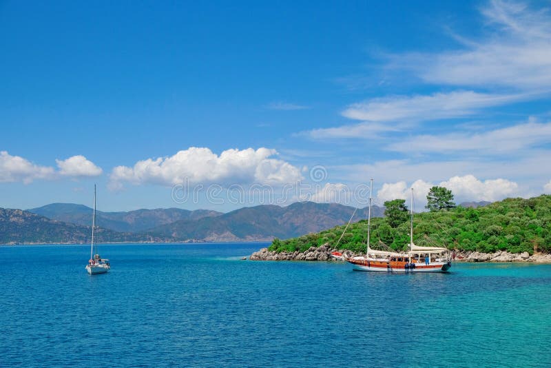 Turkey Mugla Marmaris Aegean sea. Boats in front of green mountains Turkish Mediterranean sea landscape. Yachts in Icmeler Turquoise waters. Turkey Mugla Marmaris Aegean sea. Boats in front of green mountains Turkish Mediterranean sea landscape. Yachts in Icmeler Turquoise waters