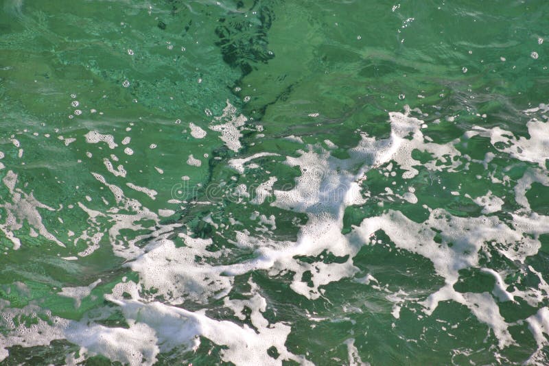 Turkusu zielony seawater z morze pianą jako tło, zakończenie w górę Powierzchnia morze z falami, pluśnięciem, pianą i bąblami, obrazy royalty free Turkusu zielony seawater z morze pianą jako tło, zakończenie w górę Powierzchnia morze z falami, pluśnięciem, pianą i bąblami, obrazy royalty free