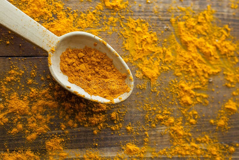 Turmeric σκόνη στο ξύλινο κουτάλι στον ξύλινο αγροτικό πίνακα κοιτάγματος στοκ εικόνα Turmeric σκόνη στο ξύλινο κουτάλι στον ξύλινο αγροτικό πίνακα κοιτάγματος στοκ εικόνα