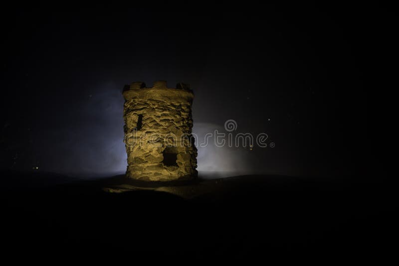 Turn de apărare piatră pe timp de noapte. miniatură a castelului medieval cu retroiluminare cu ceață tonată. decorațiuni creative royalty free stock photo