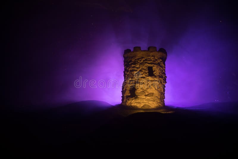 Turn de apărare piatră pe timp de noapte. miniatură a castelului medieval cu retroiluminare cu ceață tonată. decorațiuni creative stock image