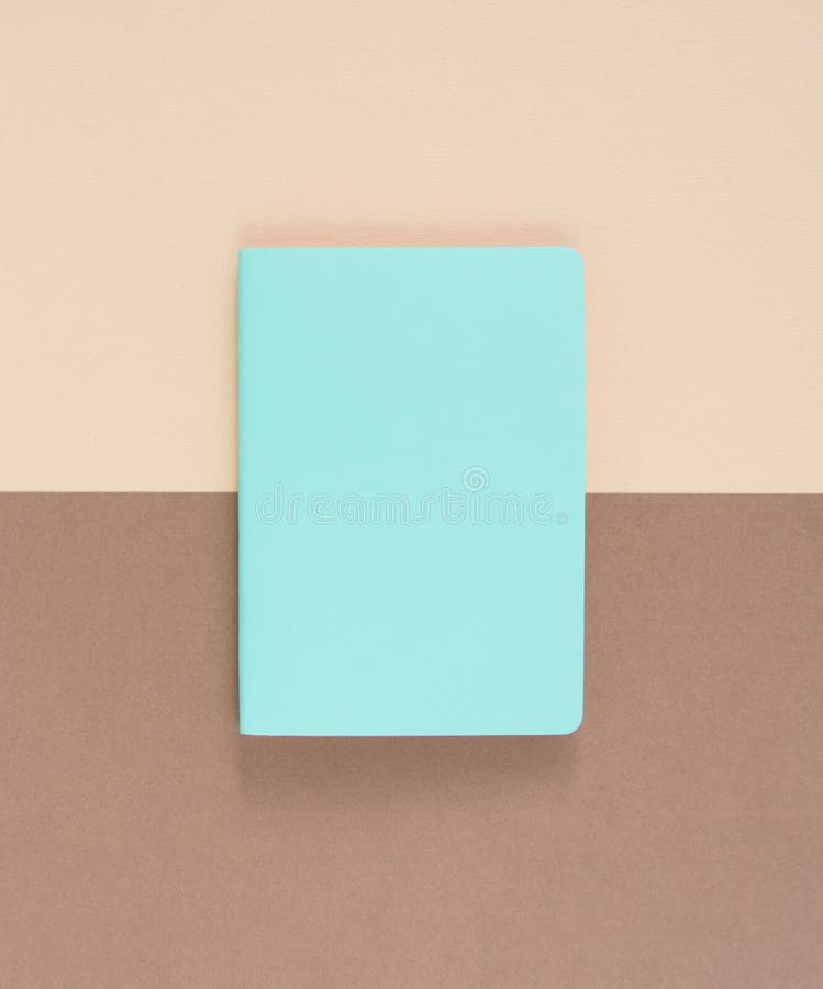 Turquoise notepad on brown background. Working place. Space for notes. Top view.