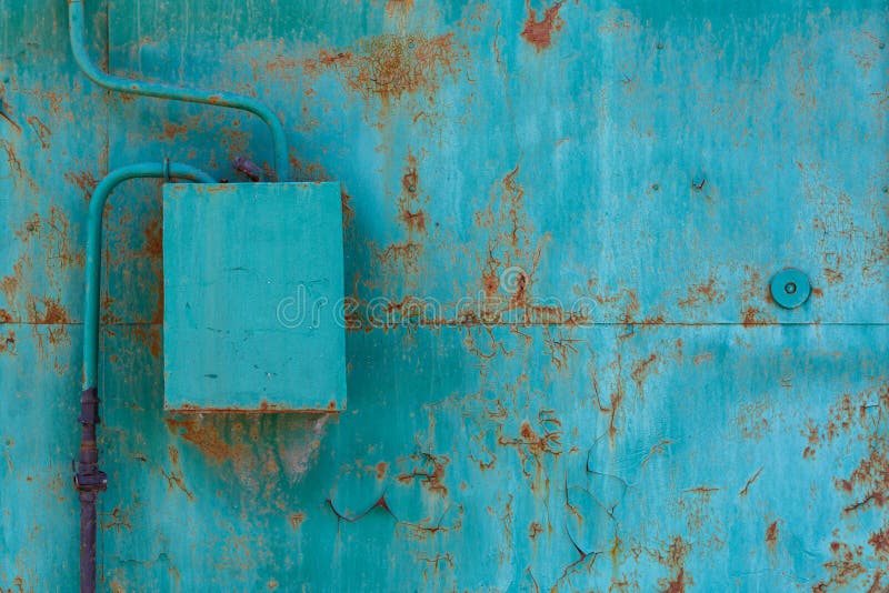 turquoise painted cracked and rusted flat steel sheet with natural gas meter and distributor box