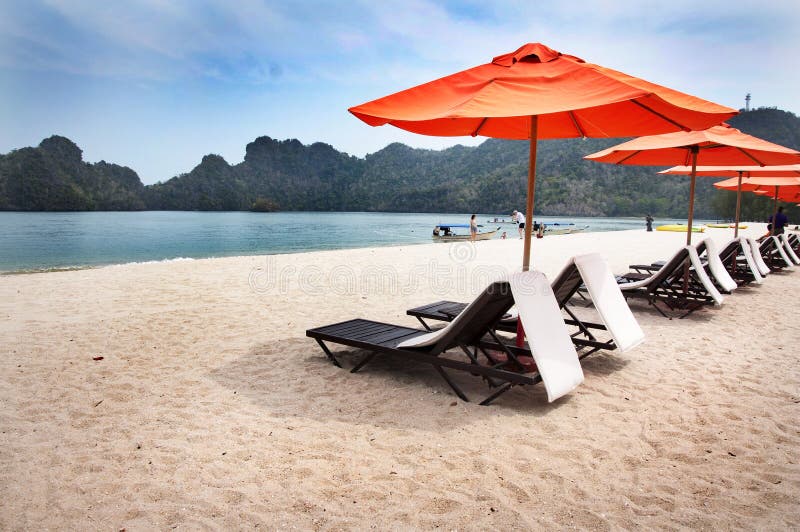 TURQUOISE SEA, DECKCHAIRS AND BEACH UMBRELLAS ON THE BEACH