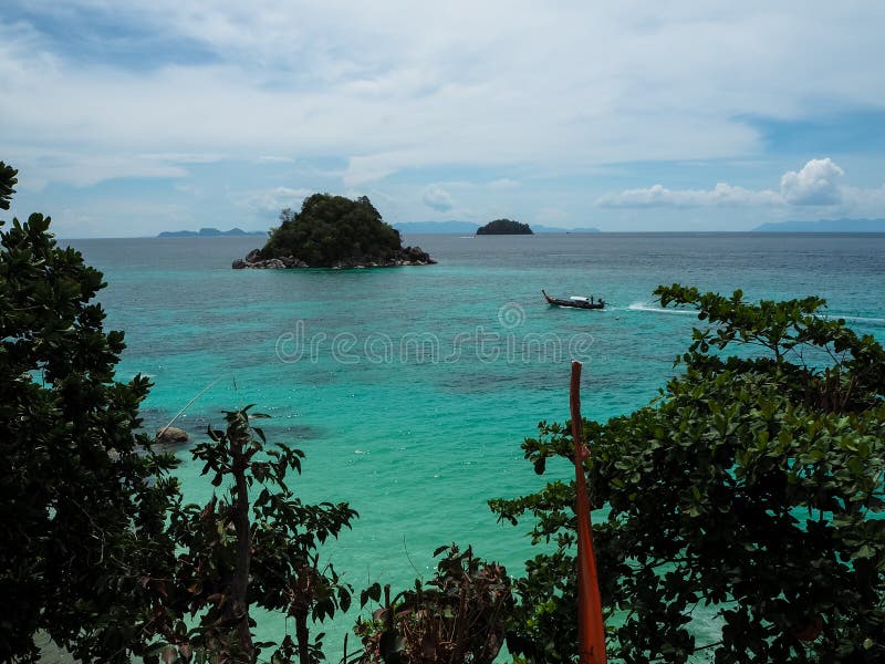 Turquoise sea view with approaching long-tail boat, small island stock photos Turquoise sea view with approaching long-tail boat, small island stock photos
