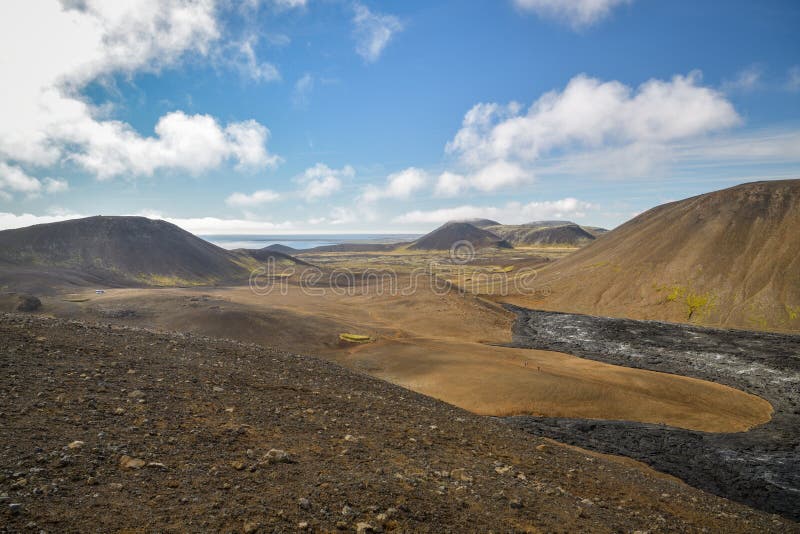 Grindavik, Iceland - September 3, 2022: Tourists hiking next to lava field from Geldingadalir volcano near Grindavik in Iceland during September 2022. Grindavik, Iceland - September 3, 2022: Tourists hiking next to lava field from Geldingadalir volcano near Grindavik in Iceland during September 2022