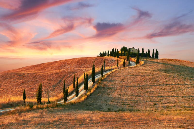 Paesaggio toscano con la casa italiana sulla cima della collina e le nuvole.