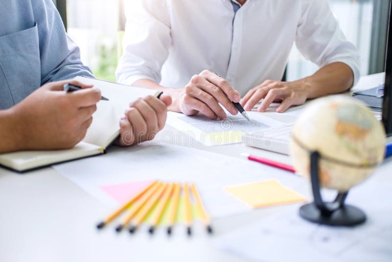 Tutor books with friends, Man sitting pointing studying together at desk with classmates exams, hands with books or textbooks stock photography Tutor books with friends, Man sitting pointing studying together at desk with classmates exams, hands with books or textbooks stock photography