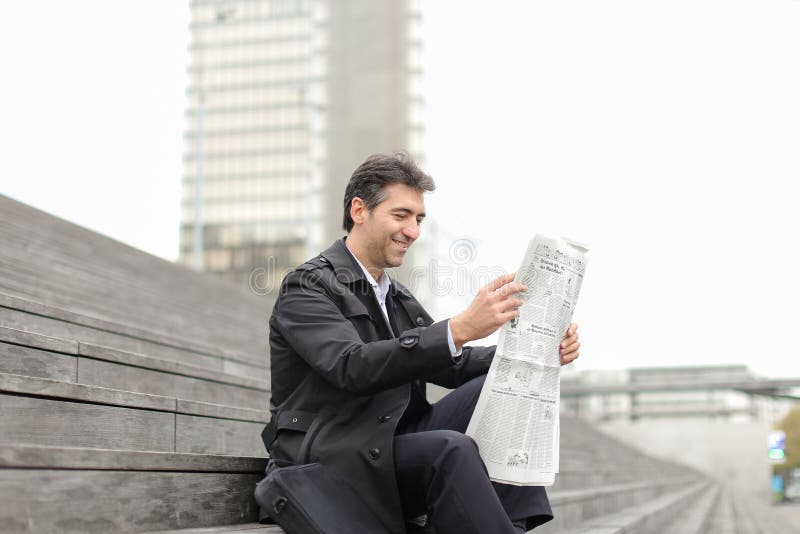 tutor masculino do negócio que senta-se em escadas e que lê o jornal imagem de stock royalty free tutor masculino do negócio que senta-se em escadas e que lê o jornal imagem de stock royalty free