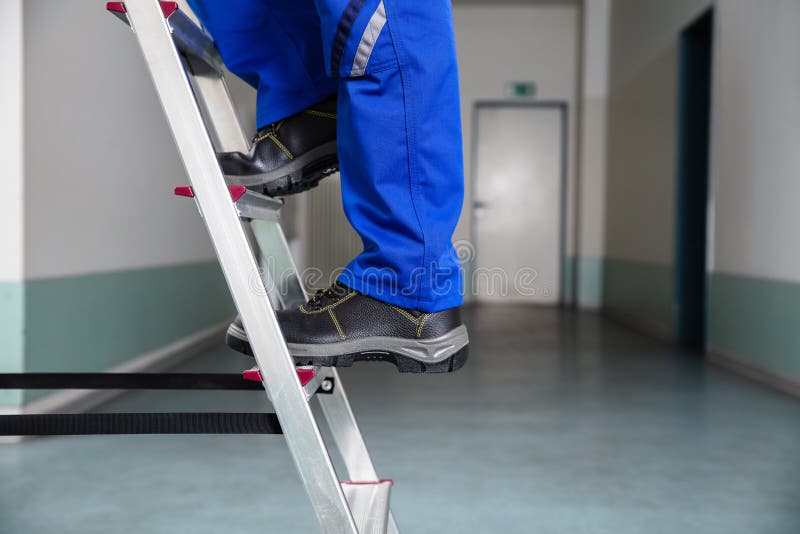 Tuttofare Climbing Ladder fotografia stock Tuttofare Climbing Ladder fotografia stock