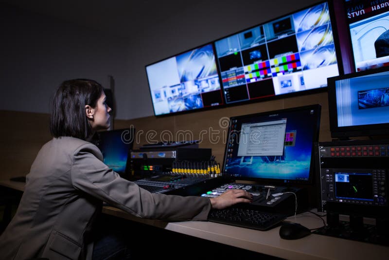 TV director at editor in studio. TV director in a television broadcast gallery.Woman producer sat at a vision mixing panel