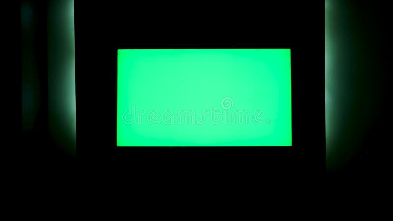 TV with Horizontal Green Screen on a Black Wall with Green Illumination