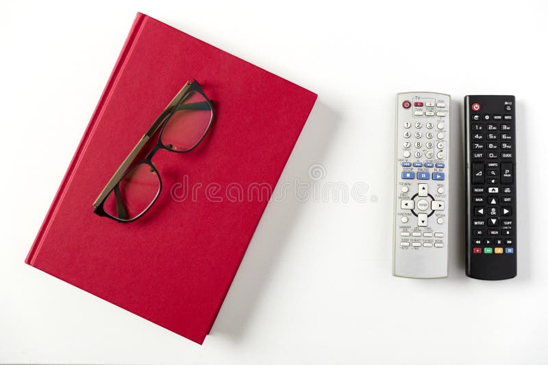 TV remote control, red book and glasses on white coffee table
