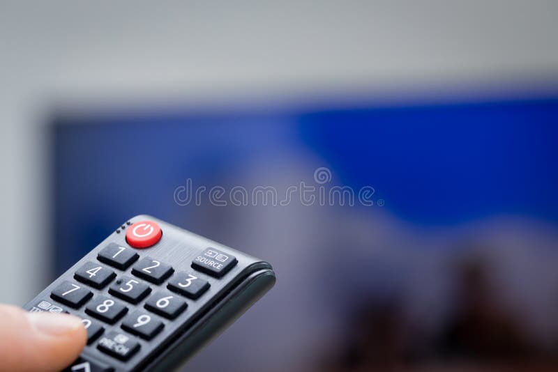 TV remote controls in hand stock image. Image of remote 166668157