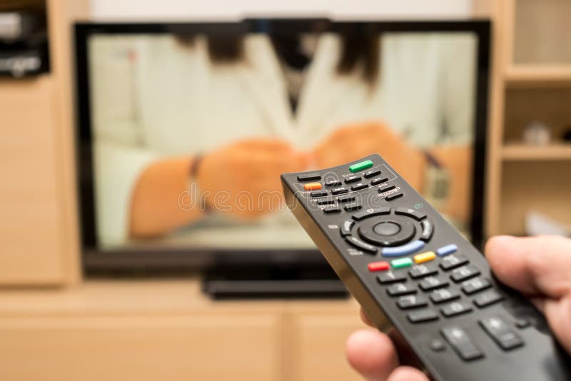 TV προσοχής και χρησιμοποίηση του μαύρου σύγχρονου μακρινού ελεγκτή στενό χέρι ελέγχου ανασκόπησης που κρατά την απομακρυσμένη τη στοκ εικόνες TV προσοχής και χρησιμοποίηση του μαύρου σύγχρονου μακρινού ελεγκτή στενό χέρι ελέγχου ανασκόπησης που κρατά την απομακρυσμένη τη στοκ εικόνες