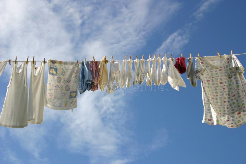 Clean fresh laundry air drying on a clothing line in a clear blue sky. Clean fresh laundry air drying on a clothing line in a clear blue sky.