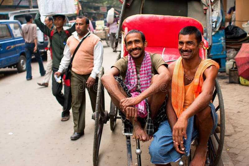 Två arbetare av räcka-draget rickshawleende
