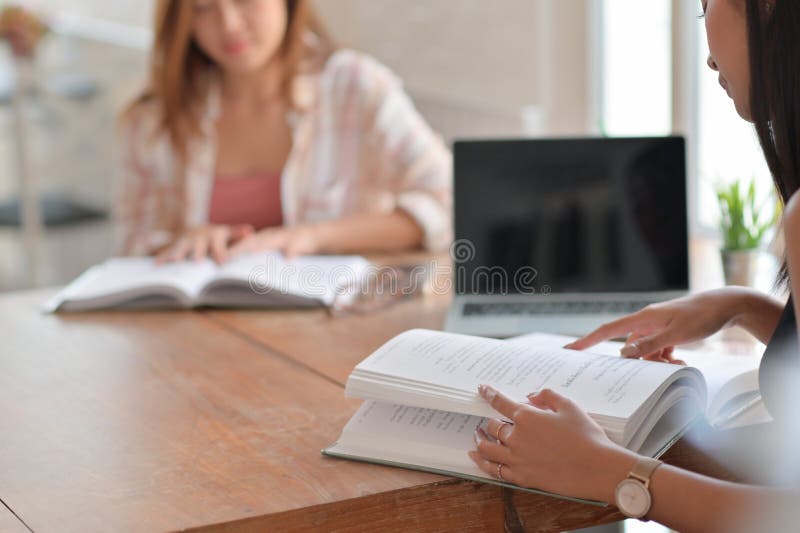 Två asiatiska kvinnliga studenter läser hårt för att förbereda sig för universitetsstudier royaltyfri bild