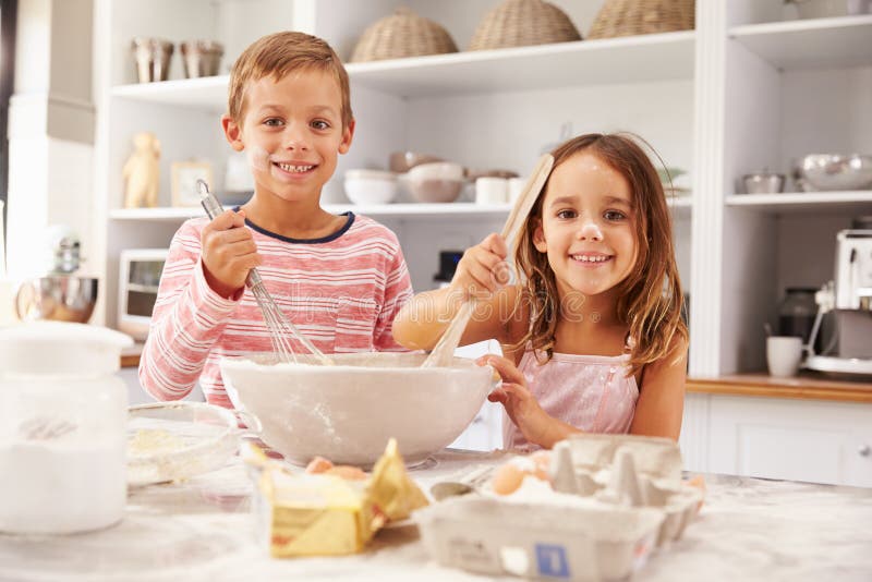 Två barn som har rolig bakning i köket