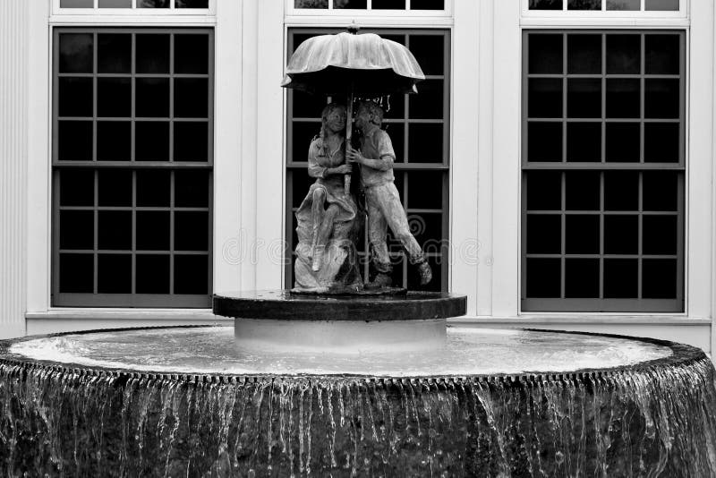 Två barn under paraplyspringbrunnen royaltyfri bild Två barn under paraplyspringbrunnen royaltyfri bild
