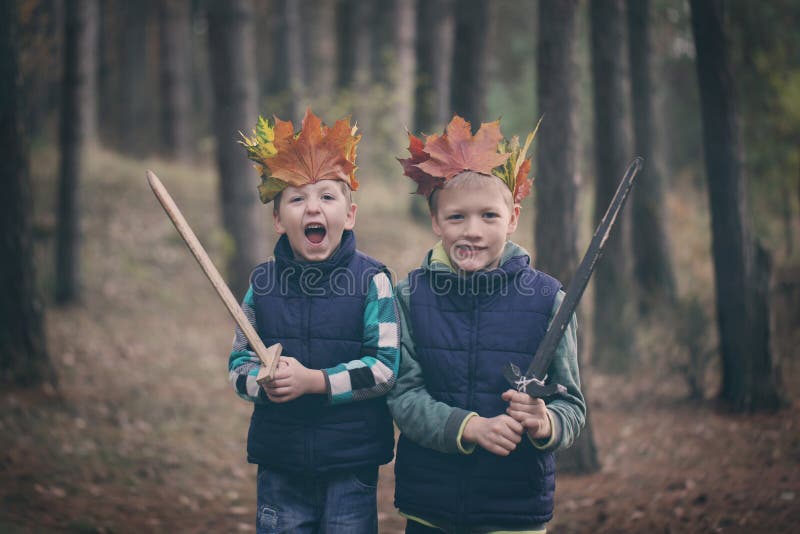 Två bröder som kelar i en skog på höstdag Små ungar hu royaltyfri foto Två bröder som kelar i en skog på höstdag Små ungar hu royaltyfri foto