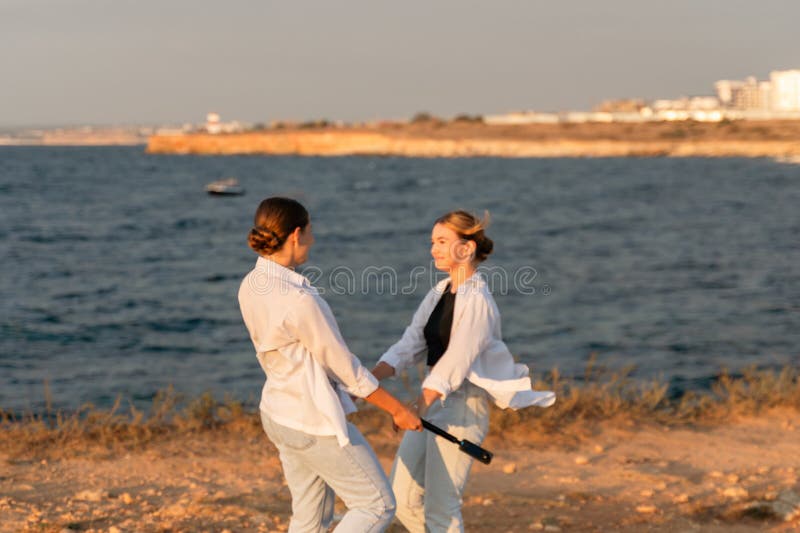 Två dansstranden solnedgång två kvinnor som dansar på stranden vid solnedgången. arkivfoto