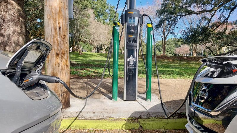 Two electric cars plugged into a charging station in New Orleans, Louisiana. Two electric cars plugged into a charging station in New Orleans, Louisiana