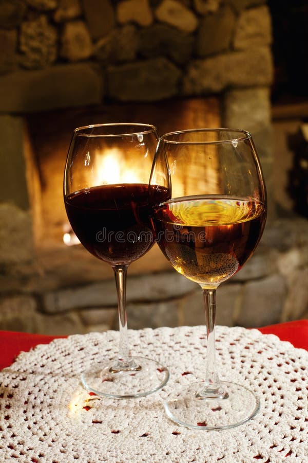Två exponeringsglas av rött vitt vin, spislampglasbakgrund romantisk xmas-vykort, hemtrevlig inre av en xmas-afton arkivbilder Två exponeringsglas av rött vitt vin, spislampglasbakgrund romantisk xmas-vykort, hemtrevlig inre av en xmas-afton arkivbilder