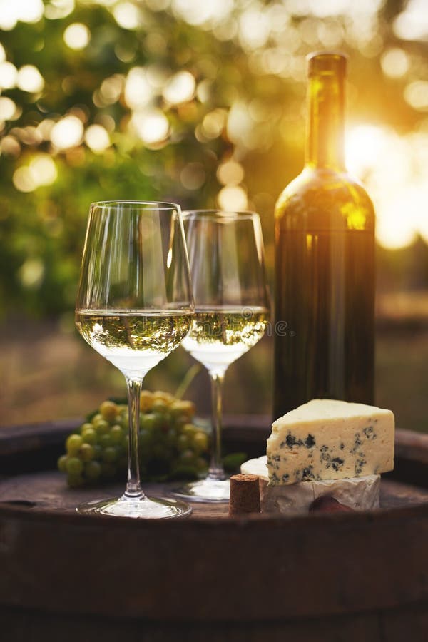 Två exponeringsglas av vitt vin på den gamla trätrumman utomhus arkivfoton Två exponeringsglas av vitt vin på den gamla trätrumman utomhus arkivfoton