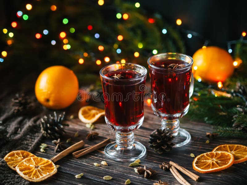 Två exponeringsglas med funderat vin på en trätabell med apelsinen, kanel, kardemumma, anisstjärnor Varm traditionell vinter arkivfoton Två exponeringsglas med funderat vin på en trätabell med apelsinen, kanel, kardemumma, anisstjärnor Varm traditionell vinter arkivfoton