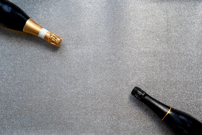 Två flaskor champagne på blankblankblankprov för text. Två flaskor champagne på silverblankblankblanksteg för textsemesterram, merry christmas och glada nyårsjubileum bröllopsfest eller födelsedagskaldekorationsparti
